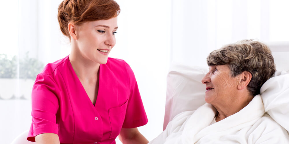 A healthcare worker with an elderly woman at a care home