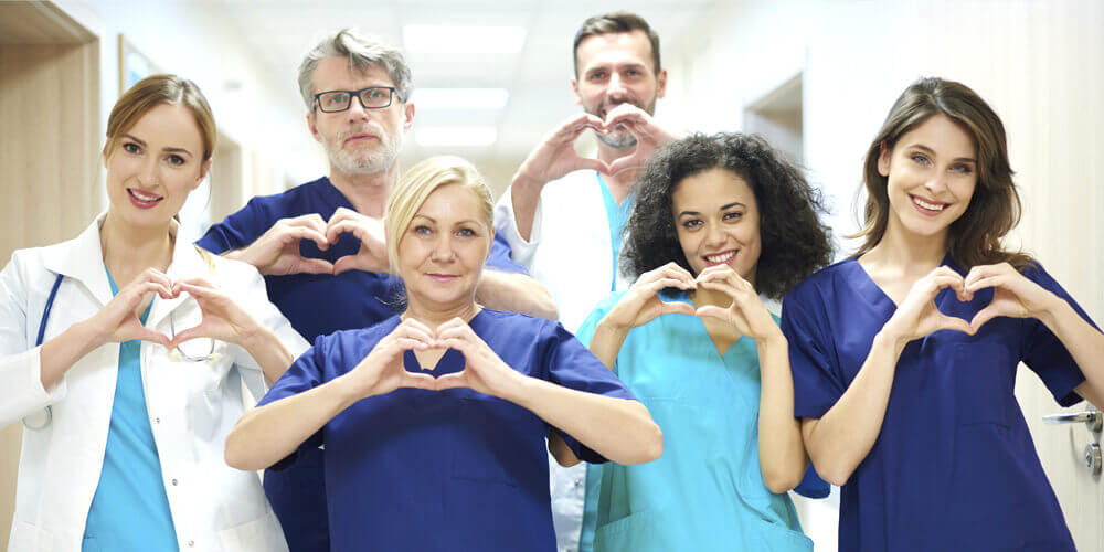 Nursing staff from diverse backgrounds stand together to pose for a photo.