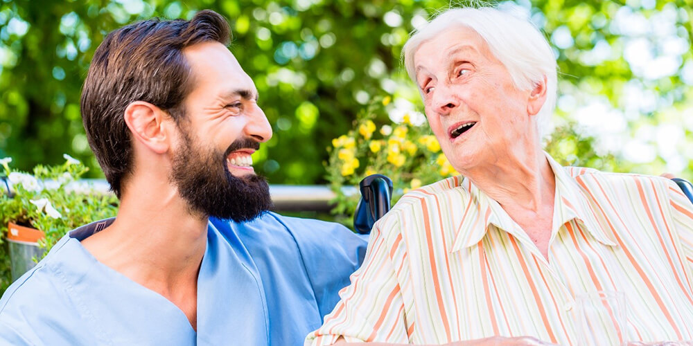 A caregiver engages a care home resident in activities.