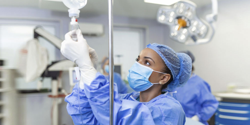 A scrubbed theatre nurse preps for surgery inside the operating room.