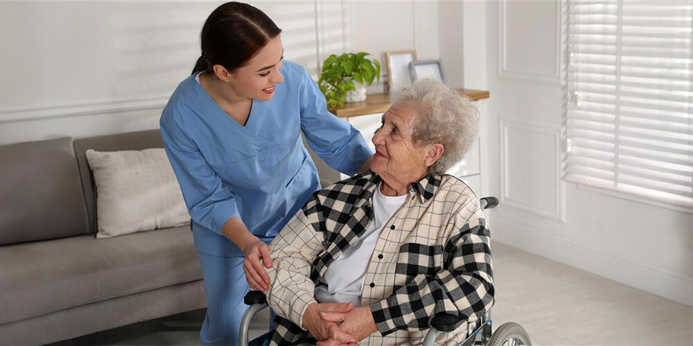 A nurse leader standing at the front of a board, addressing a group of staff members.