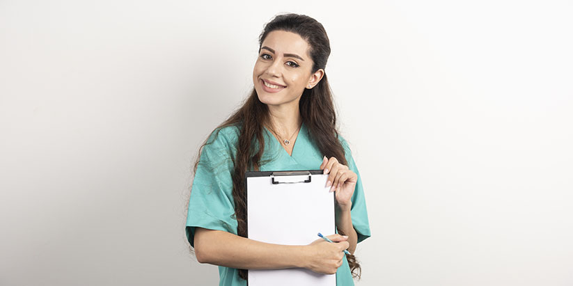 A nurse smiles as she poses for a photograph while holding a client file.