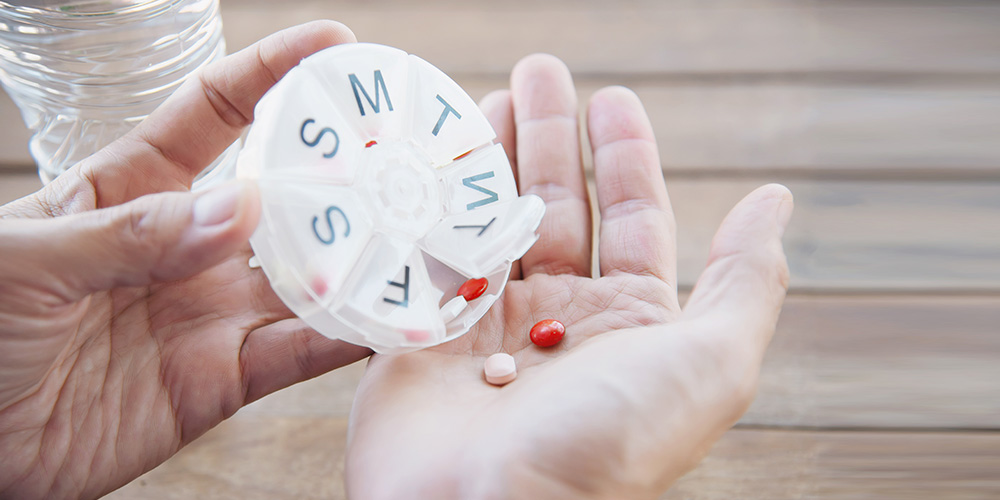 A hand holding medicines implying the benefits of medication administration