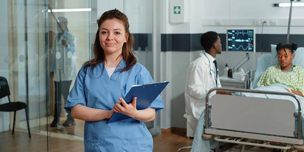 A nursing staff working as an agency nurse stands in a hospital corridor.