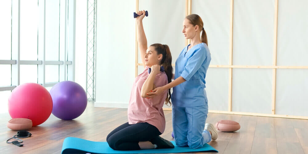 A nurse is helping another healthcare staff do a workout to de-stress and relax.